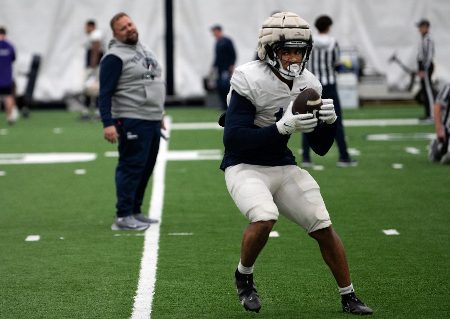 Penn State offensive coordinator Andy Kotelnicki watches running back Nicholas Singleton run through a drill during practice at Holuba Hall.